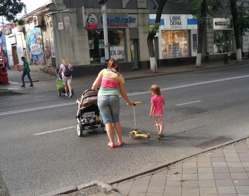 Мама с ребенком проходят через улицу